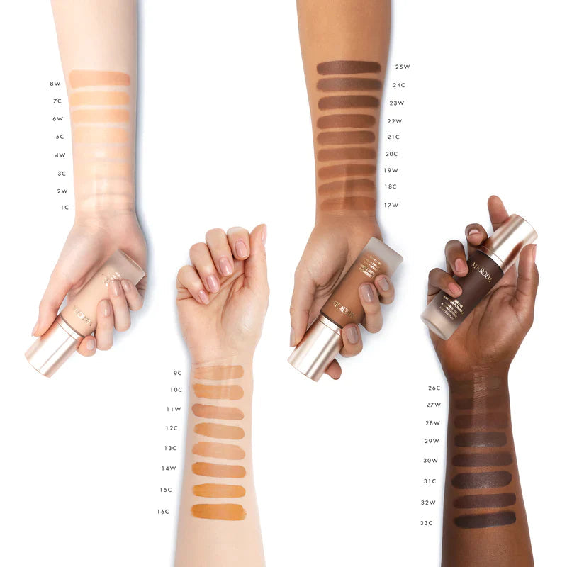 Universal Foundation shade swatches on four arms with diverse skin tones holding Meroda Cosmetics bottles.