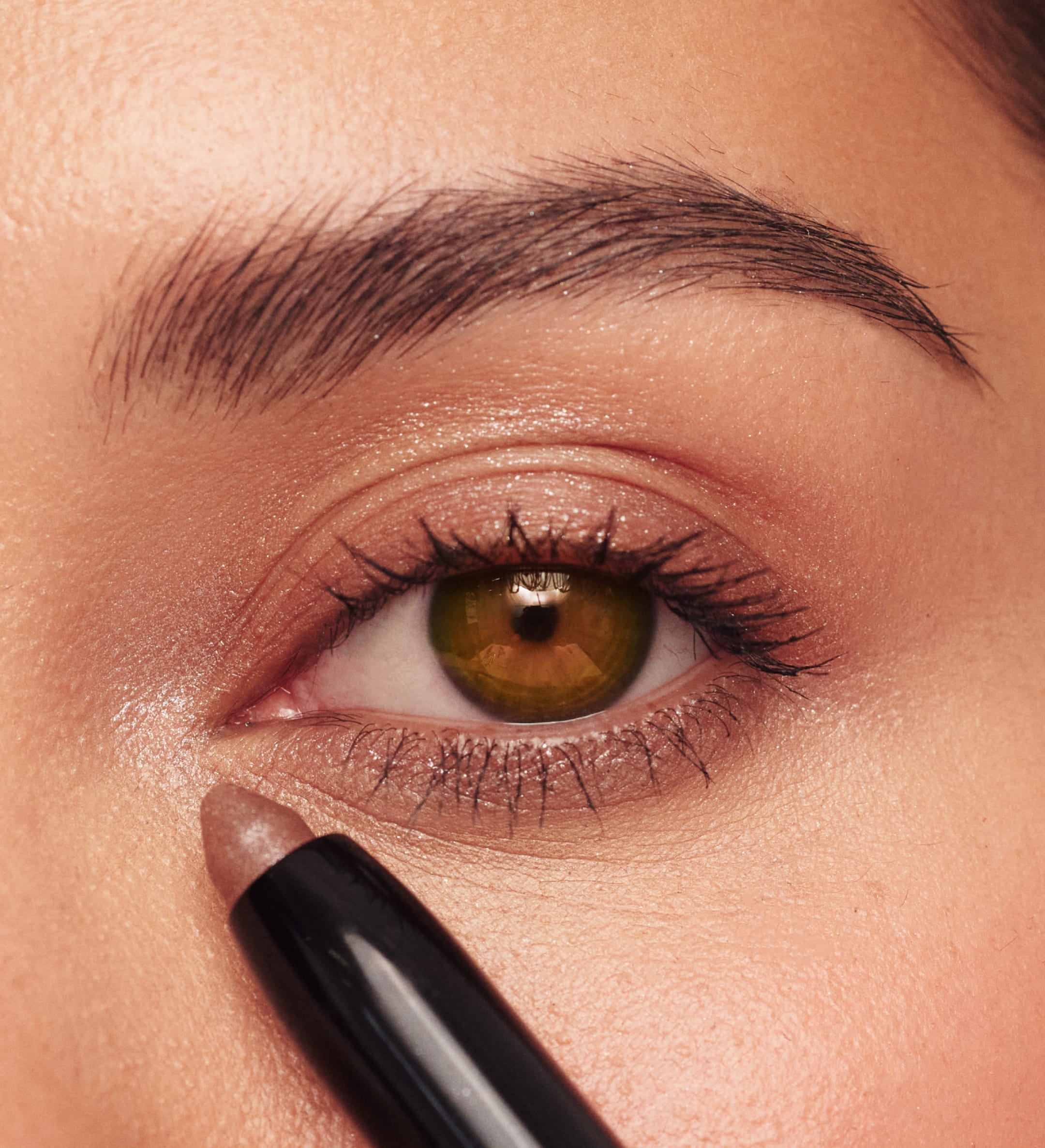 Meroda Cosmetics Eye Perfecting Shimmer Stick in Bronze applied to the eye for a radiant, glowing finish.