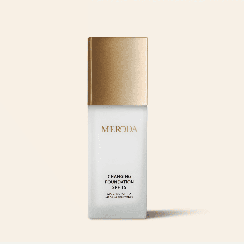 Meroda Cosmetics Changing Foundation SPF 15 bottle featuring a metallic gold cap and color-adapting pigments.