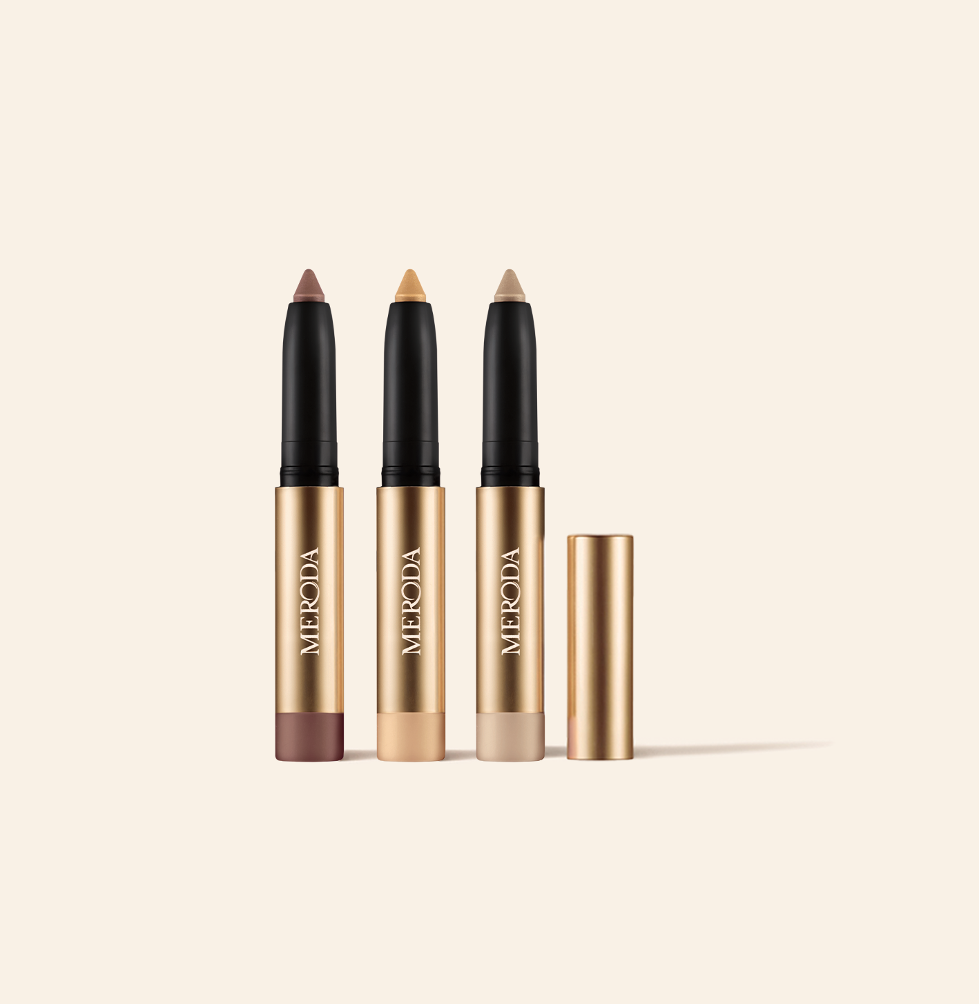 Meroda Cosmetics Mini Eye Shimmer Set featuring three gold sticks in radiant mauve, gold, and pearl shades.