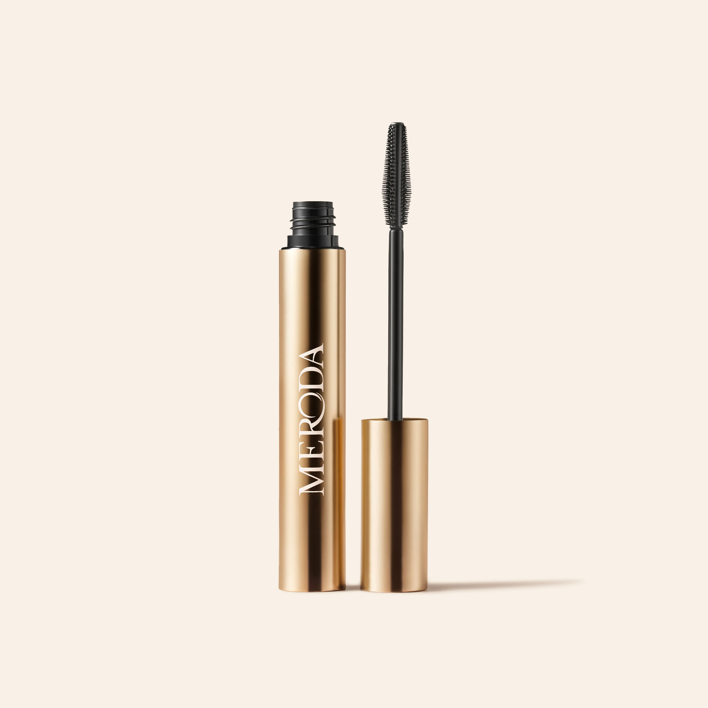 Meroda Cosmetics Gilded Lashes Mascara featuring a gold metallic tube and silicone wand for lengthening and volumizing