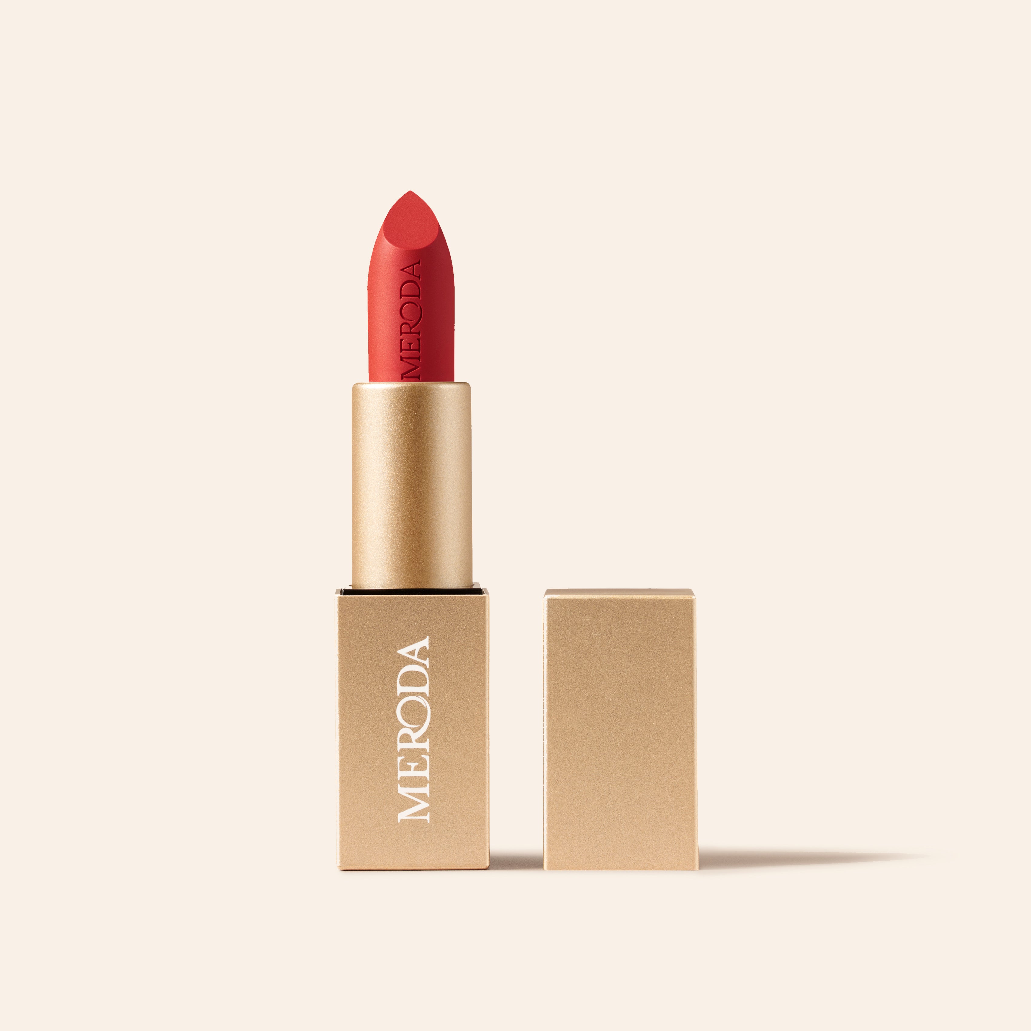 Meroda Velvet Dream Lipstick in Luscious Red in an open gold case against a light background.