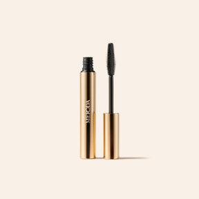 Meroda Cosmetics Mini Mascara in a gold tube with a black wand applicator for lengthening and volumizing lashes.
