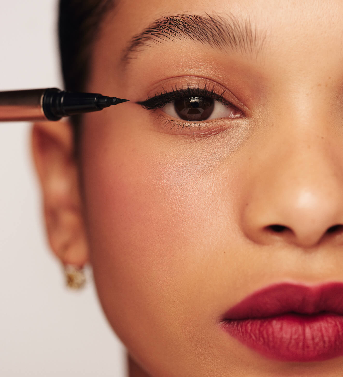 It's All About The Wing Liquid Waterproof Eyeliner applied to a model for a sharp, black winged look.