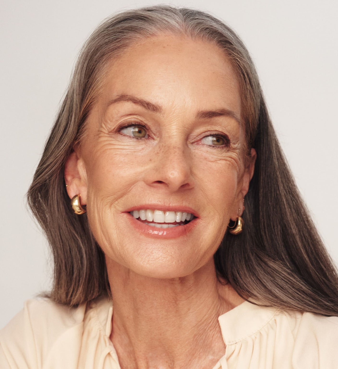 The Valentines Bundle featuring The Soft Tan Bronzer on a smiling model with gray hair for a radiant glow.