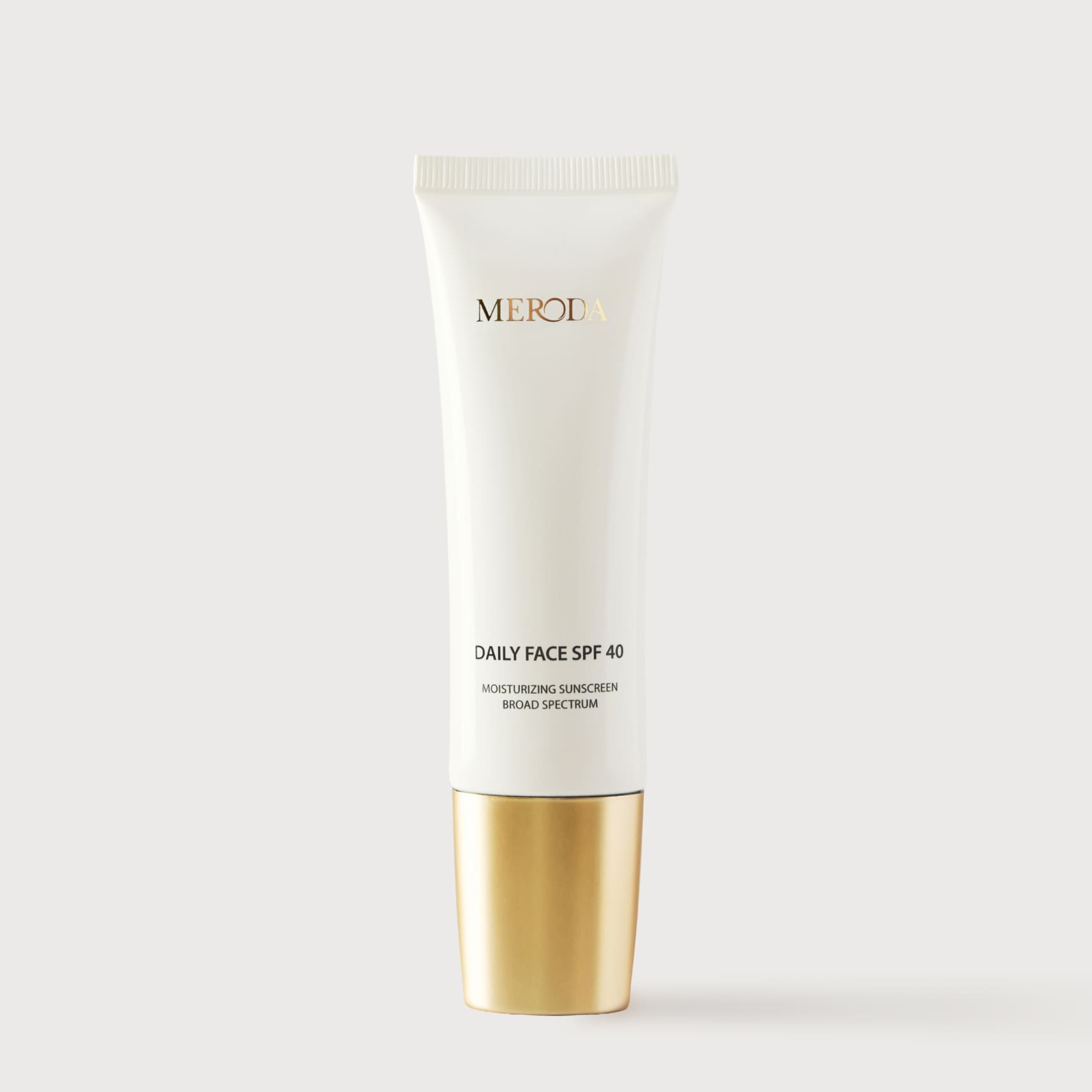 Daily Face SPF 40 white tube with a metallic gold cap and minimalist black and gold typography.