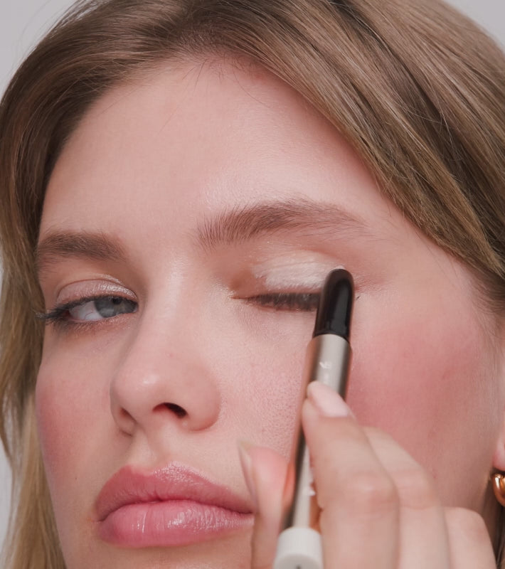 Applying Eye Perfecting Shimmer Stick to eyelids for a radiant, crease-proof glow and brightened eye look.